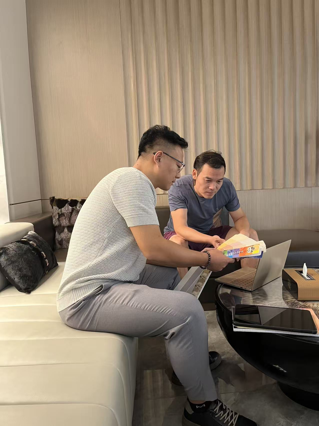 Two project team members reviewing and discussing material samples indoors.
